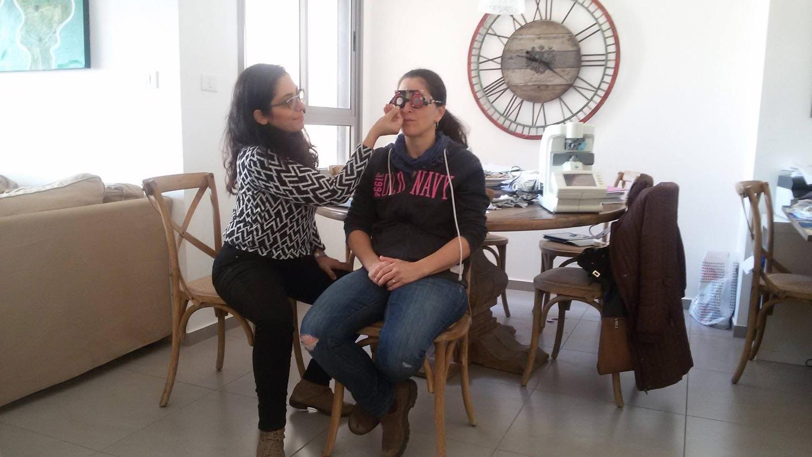 תמונה 3: בדיקת ראיה והתאמת משקפיים בבית לקוח על ידי אופטומטריסט של אופטיק-הום