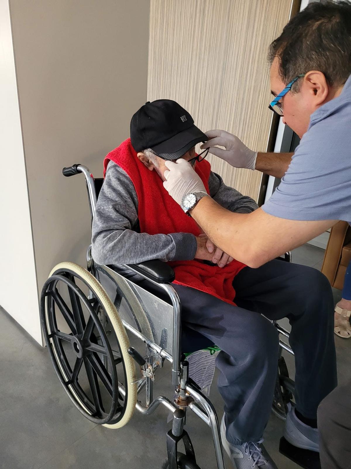 תמונה 7: בדיקת ראיה והתאמת משקפיים בבית לקוח על ידי אופטומטריסט של אופטיק-הום